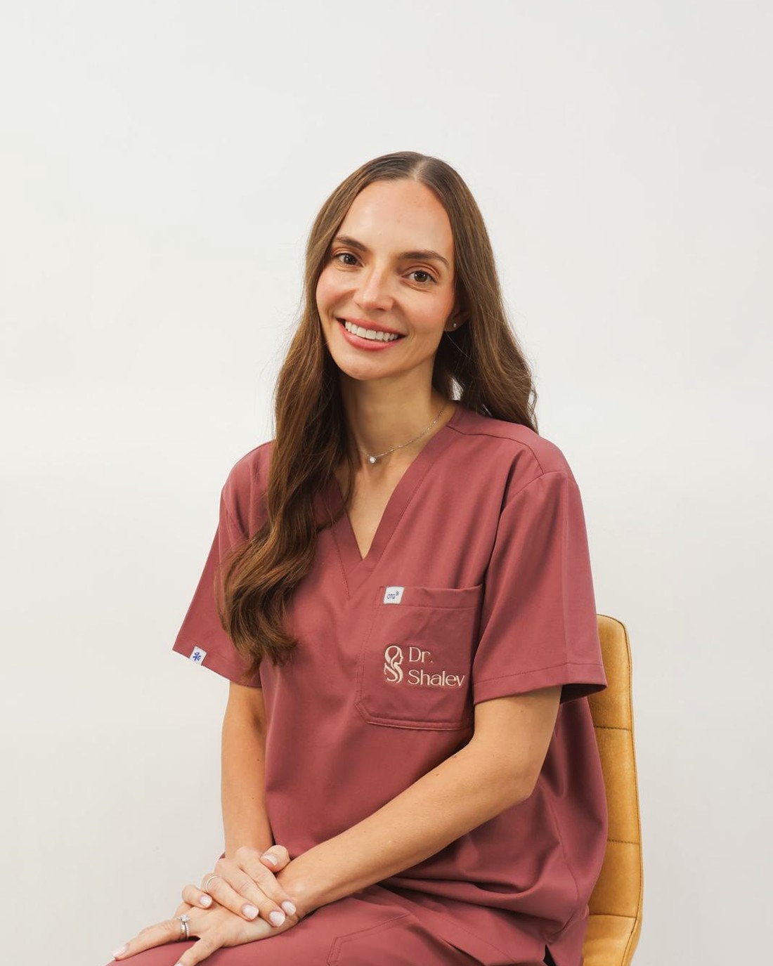 Dr. Maria Shalev, seated, in clinic uniform.